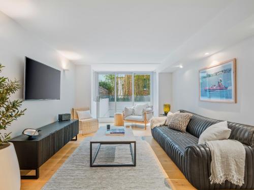 a living room with a couch and a tv at Bondi Pacific Studio - Managed by X Hospitality in Sydney
