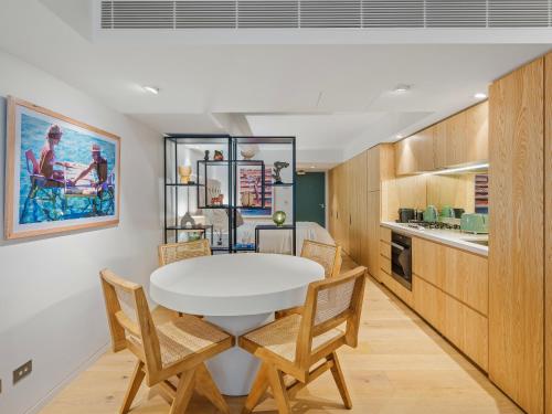 a kitchen and dining room with a white table and chairs at Bondi Pacific Studio - Managed by X Hospitality in Sydney