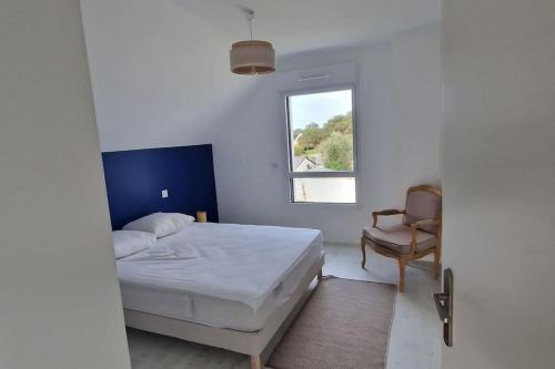 une chambre avec un lit, une chaise et une fenêtre dans l'établissement La Villa des Salines, à Carnac