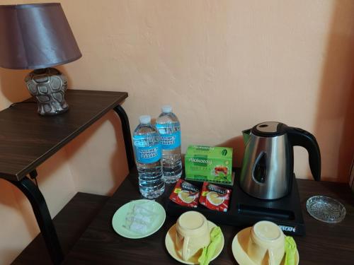 a table with a coffee maker and water bottles on it at TGH Guest House Badian in Badian