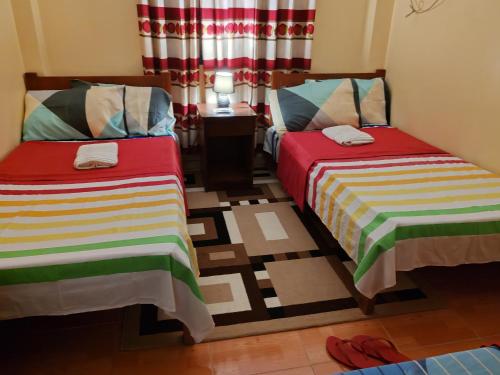 two beds sitting next to each other in a room at TGH Guest House Badian in Badian