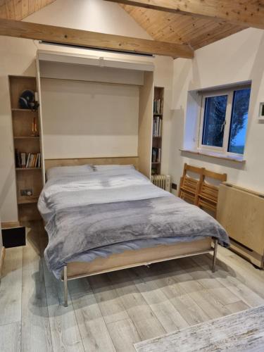 Bett in einem Schlafzimmer mit Holzdecke in der Unterkunft Cosy Cabin near Lough Hyne in Skibbereen