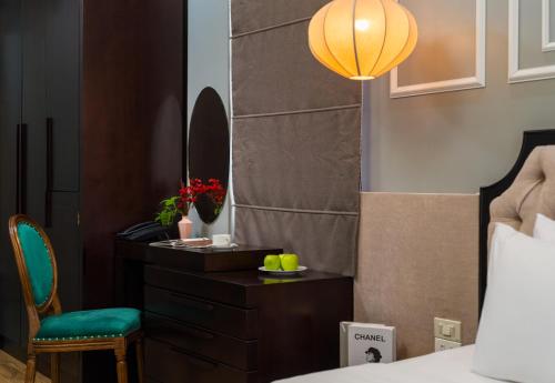 a bedroom with a bed and a desk and a chair at Bella Rosa Hotel & Travel in Hanoi