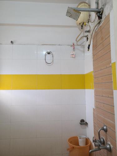 アーメダバードにあるHotel Motera Innの黄色と白の壁のバスルーム(トイレ付)