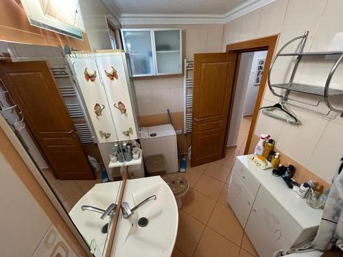 een badkamer met een wastafel, een toilet en een spiegel bij Apartament in Ploieşti