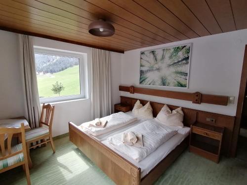 a bedroom with a bed with two dogs laying on it at Ferienhof zur Sonne in Tux