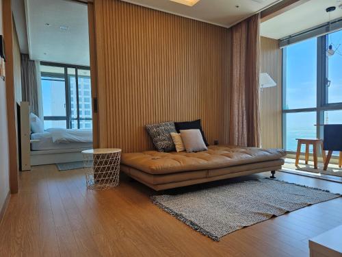 a living room with a couch and a bedroom at 엘본 더 스테이 X 보나 트래블 in Busan