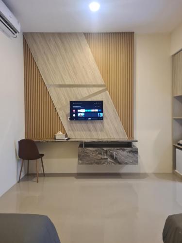 a living room with a tv on a wall at Merpati inn hotel in Dompu