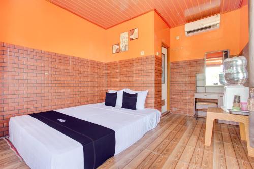 1 dormitorio con cama y pared de ladrillo en Collection O 93742 Sidodadi Hotel Dan Resto en Yogyakarta