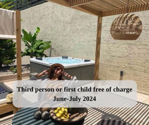 a woman sitting in a hot tub in a patio at Marble Luxury Suites in Karteros