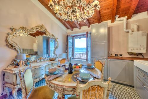 cocina con mesa y lámpara de araña en Laetitia Historic Center Fantastic view L - Happy Rentals en Salò