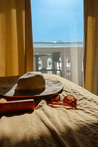 a hat and sunglasses on a table with a hat and glasses at Hôtel Du Golfe in Ajaccio