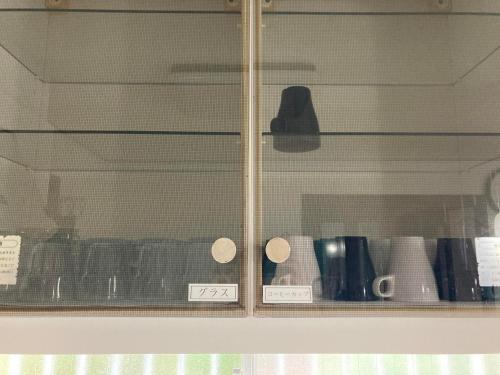 a glass display case with cups in it at シテコベハウス in Yokosuka