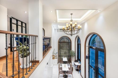 a dining room with tables and chairs and a chandelier at Cherie Bangkok Boutique Hotel in Bangkok