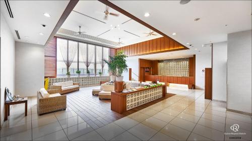 a large living room with couches and tables and windows at Daiwa Roynet Hotel Naha Omoromachi in Naha
