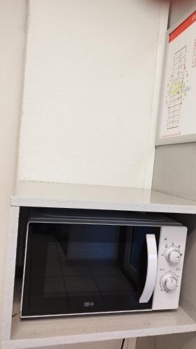 a microwave oven sitting on top of a shelf at Premiere Classe La Rochelle Sud - Angoulins in Angoulins