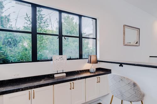 een keuken met ramen en een bureau met een lamp bij Four Bedrooms Luxurious Townhouse in Los Angeles