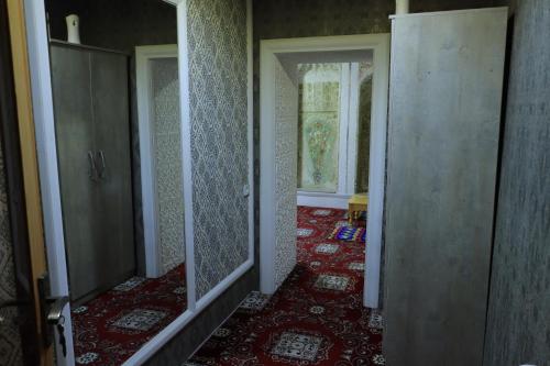 un pasillo vacío con espejos en una casa antigua en Hotel ALISHER, en Bukhara