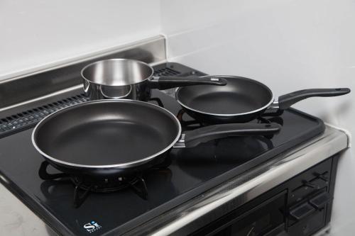 two pots and pans sitting on top of a stove at ガジュマルの庭～itoman in Ō