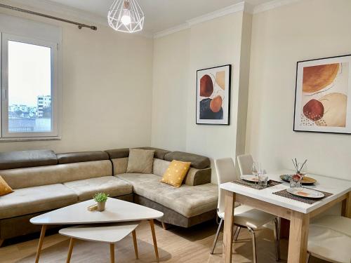 een woonkamer met een bank en een tafel bij Peaceful Condo in City Center in Durrës