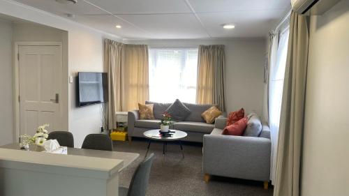 sala de estar con sofá y mesa en Comfy & Sunny home in Wellington en Wellington