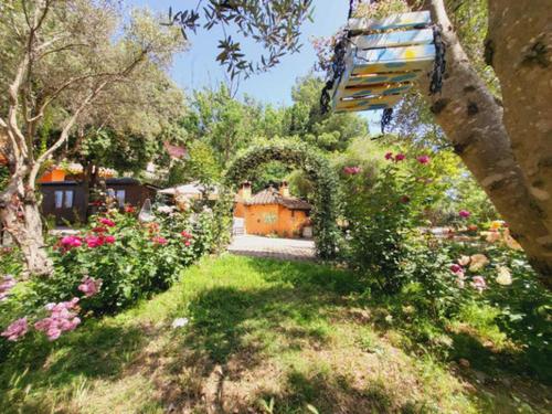 un giardino con panchina e fiori in un cortile di B&B Il Girasole a SantʼAnna Arresi