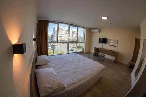 sypialnia z łóżkiem i dużym oknem w obiekcie HOTEL BAYKO w Płowdiwie