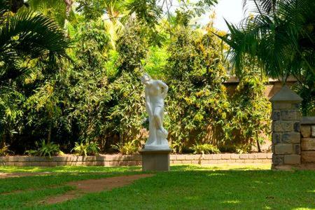 a statue of a cat on a pedestal in the grass at Villa Dhanu in Galle
