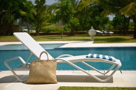 a purse sitting on a chair next to a pool at Villa Dhanu in Galle