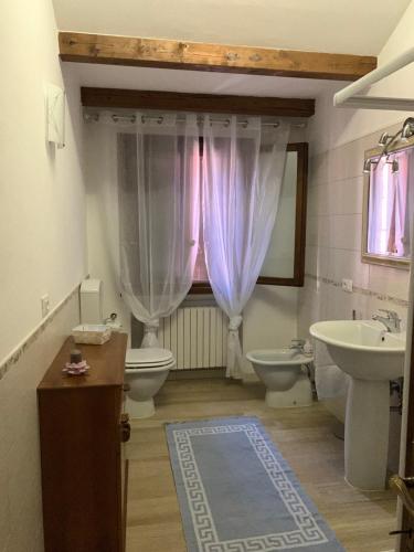 baño con 2 aseos, lavamanos y ventana en a casa di lu en Torri di Quartesolo