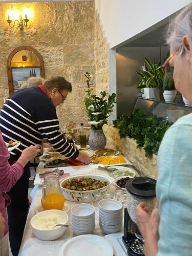 a group of people standing in a kitchen preparing food at Costas Inn in Spílion