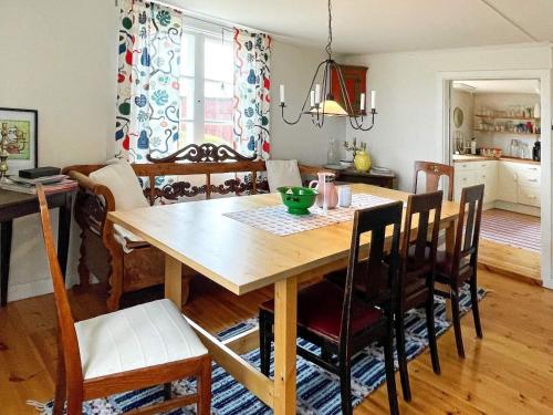 a kitchen and dining room with a wooden table and chairs at 8 person holiday home in HÖGSBY in Högsby