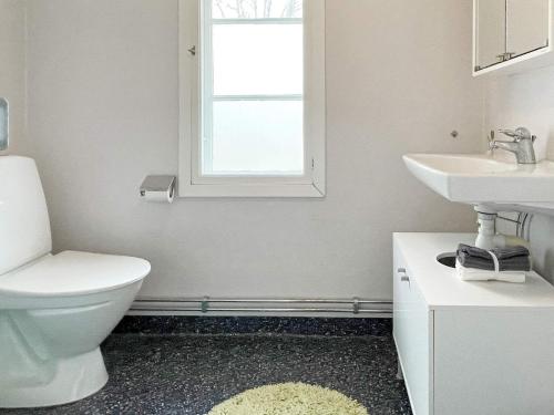 a bathroom with a toilet and a sink and a window at 8 person holiday home in HÖGSBY in Högsby
