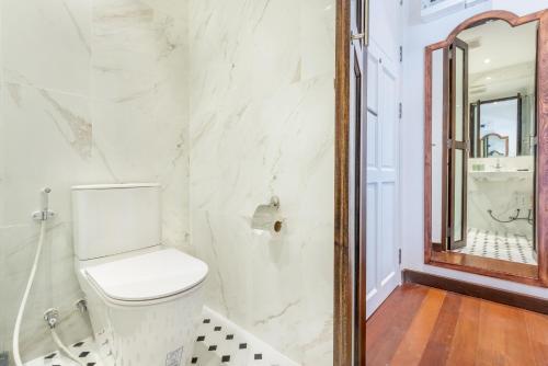 a bathroom with a toilet and a mirror at Cherie Bangkok Boutique Hotel in Bangkok