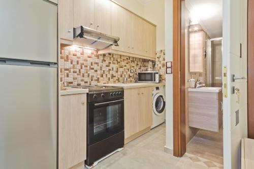 a kitchen with a stove and a washer and dryer at Olive Studios Karpathos Studio #4 in Karpathos Town
