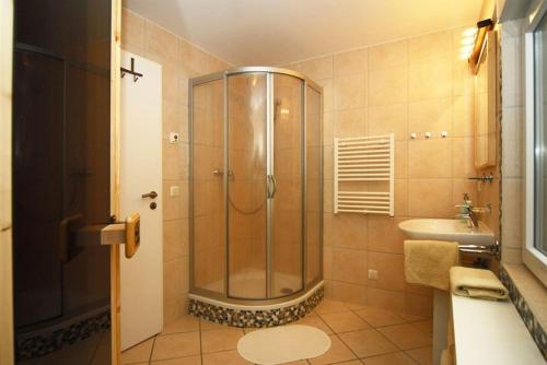 La salle de bains est pourvue d'une douche et d'un lavabo. dans l'établissement Ferienhaus Waldidyll, à Zempin