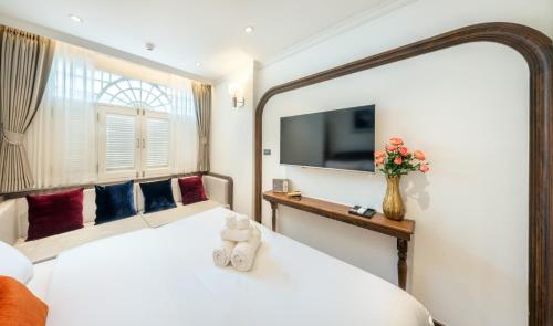 a hotel room with a bed and a tv at Cherie Bangkok Boutique Hotel in Bangkok
