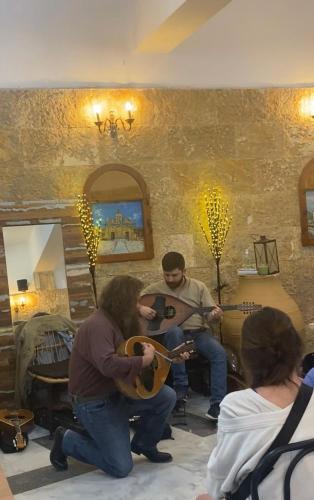 a group of people playing guitars in a room at Costas Inn in Spílion