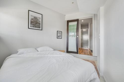 - une chambre blanche avec un grand lit et une fenêtre dans l'établissement Grand Loft Spacieux Paris 8 Pers WIfi CDG, à Bagnolet