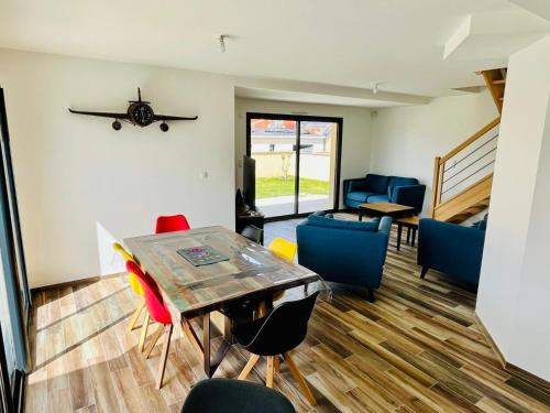 un salon avec une table et des chaises dans l'établissement Beach house, à Gouville-sur-Mer