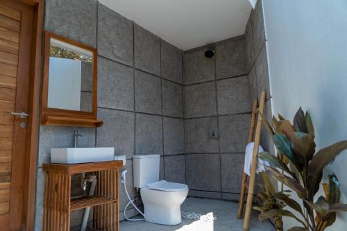 uma casa de banho com um WC e um espelho. em Cosmo House Keramas em Keramas
