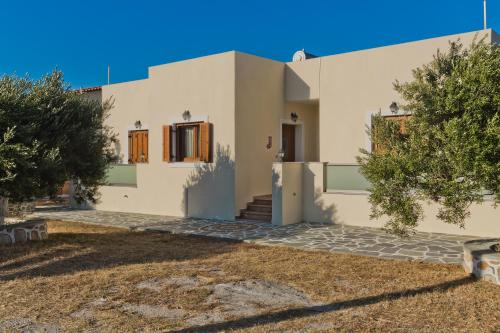 a white house with trees in front of it at Olive Studios Karpathos Studio #4 in Karpathos Town