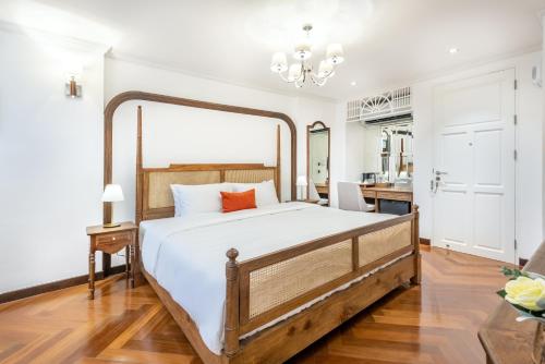 a bedroom with a large bed with white sheets at Cherie Bangkok Boutique Hotel in Bangkok