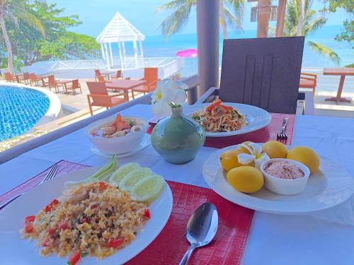 a table with plates of food on top of it at Bhundhari Resort & Villas Samui in Chaweng