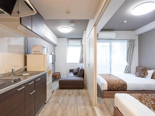 um quarto de hotel com uma cama e uma cozinha com um lavatório em Dream Inn Hakata em Fukuoka