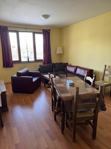 een woonkamer met een bank en een tafel bij Vacation apartment Evel in Bansko