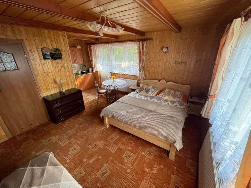 a bedroom with a bed and a table in it at POKOJE GOŚCINNE U ANIELI in Szczyrk
