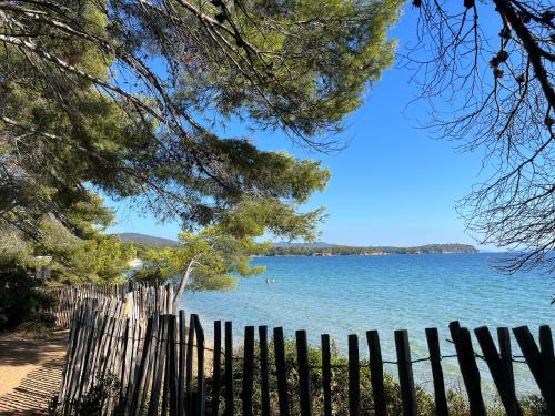 - une vue sur un lac à travers une clôture en bois dans l'établissement Bienvenue au village de la mer, à La Londe-les-Maures