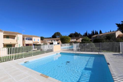 une grande piscine bleue dans une cour dans l'établissement Bienvenue au village de la mer, à La Londe-les-Maures
