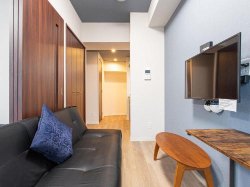 a living room with a couch and a tv at Dream Inn Hakata in Fukuoka